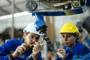 robótico técnicos apretar y aflojar componentes con destornillador y alicate a realizar la seguridad mantenimiento. medición actual, Voltaje, resistencia, capacidad, temperatura con digital abrazadera metro. foto