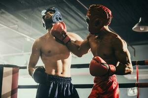 Boxer utilizar varios puñetazo combinaciones, incluso el pinchazo, gancho, uppercut, cruz, balancearse, derecho. consiguiendo en cerca a hacer adversario en cuerdas y knockear. boxeo campeones ganar el redondo en boxeo anillo foto