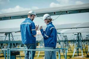 Solar engineers visually examine panel arrays on farm sites using blueprints and drawings to ensure that the alignment, surface, sunlight access, and structural stability meet standard requirements. photo