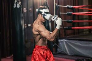 Professional boxer wear virtual reality headsets to engage in immersive boxing workouts simulations while practicing their punching techniques. Live, customized training sessions with boxing coach photo