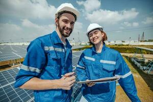 Solar engineers visually examine panel arrays on farm sites using blueprints and drawings to ensure that the alignment, surface, sunlight access, and structural stability meet standard requirements. photo