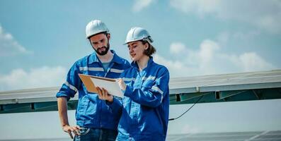 Solar engineers visually examine panel arrays on farm sites using blueprints and drawings to ensure that the alignment, surface, sunlight access, and structural stability meet standard requirements. photo