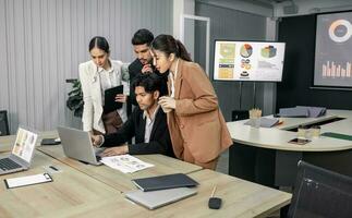 Financial advisors collaborate to assess a company's financial performance using data from its operational activities. Team members work together in a discussions meeting to develop a business plan. photo