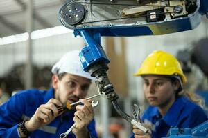 robótico técnicos apretar y aflojar componentes con destornillador y alicate a realizar la seguridad mantenimiento. medición actual, Voltaje, resistencia, capacidad, temperatura con digital abrazadera metro. foto