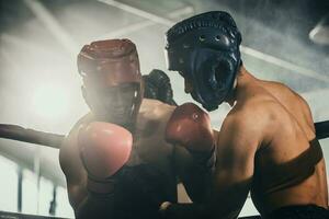 Boxer use various punch combinations, including the jab, hook, uppercut, cross, swing, straight. Getting in close to make opponent on ropes and knockout. Boxing champions win the round in boxing ring photo