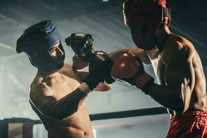 Boxer use various punch combinations, including the jab, hook, uppercut, cross, swing, straight. Getting in close to make opponent on ropes and knockout. Boxing champions win the round in boxing ring photo