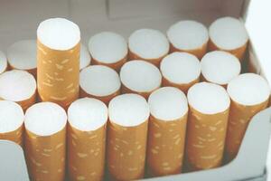 despegue el paquete de cigarrillos prepárelo fumando un cigarrillo. línea de embalaje. la foto filtra la luz natural.