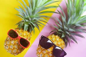 pineapple wearing sunglasses on a yellow background photo