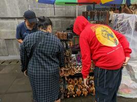 Blitar, indonesia - april, 2023 - a seller who is selling various local souvenirs to buyers photo