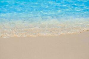 hermosa arenoso playa y suave azul Oceano ola. verano antecedentes concepto foto