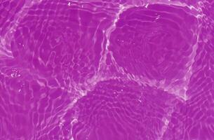 púrpura agua con ondas en el superficie. desenfocar borroso transparente rosado de colores claro calma agua superficie textura con salpicaduras y burbujas agua olas con brillante modelo textura antecedentes. foto