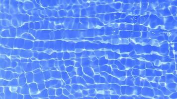 Blue water with ripples on the surface. Defocus blurred transparent blue colored clear calm water surface texture with splashes and bubbles. Water waves with shining pattern texture background. photo