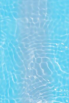 Blue water with ripples on the surface. Defocus blurred transparent blue colored clear calm water surface texture with splashes and bubbles. Water waves with shining pattern texture background. photo