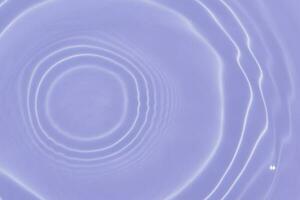 Purple water with ripples on the surface. Defocus blurred transparent pink colored clear calm water surface texture with splashes and bubbles. Water waves with shining pattern texture background. photo