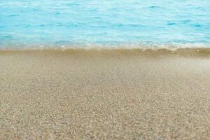 Blue water with ripples on the surface with sand sea beach. Defocus blurred transparent blue water ripple surface texture with splashes and bubbles. Water wave with shining pattern texture background. photo