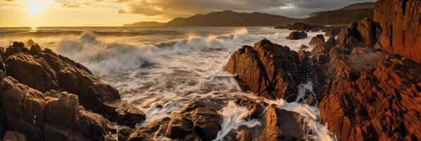 The waves are crashing over the rocks at sunset. photo