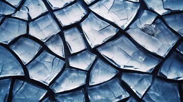 A broken glass surface with cracks and shattered pieces. photo