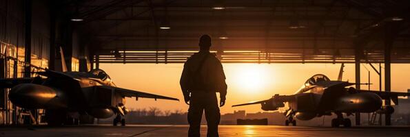 puesta de sol retroiluminado ver de militar combatiente chorro piloto junto a estacionado militar fuerza Aerea avión siguiente a cuartel o hangar como amplio bandera con copyspace zona para mundo guerra conflictos ai generativo foto