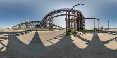spherical 360 hdri panorama near industrial architecture and communications, pipes and metal structures in equirectangular seamless projection photo