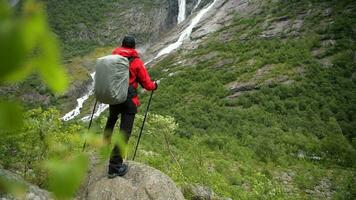 kaukasisch Backpacker genießen szenisch Wasserfall Aussicht im das Norwegen. video
