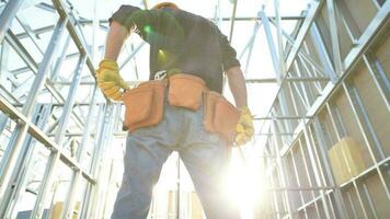 caucasico costruzione lavoratore e il di recente finito acciaio telaio di il costruzione. video