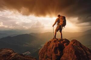 Successful hiker hiking a mountain pointing to the sunset. photo