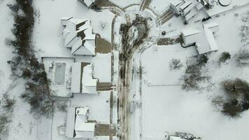 neige couvert survol de une petit rural de banlieue quartier. une marcher vers le bas une de banlieue rue dans le milieu de l'hiver. video