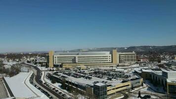 Beautiful sunny day overlooking a multi building complex in winter. Snow covered mountains in the background. video