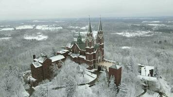 Aerial view of religious building on mountain in Wisconsin. Snow covered forest. Cloudy overcast winter sky. Plowed parking area and sidewalks. video