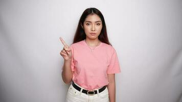 Beautiful Asian woman wearing pink shirt with hand gesture pose rejection or prohibition with copy space in Studio with White background video