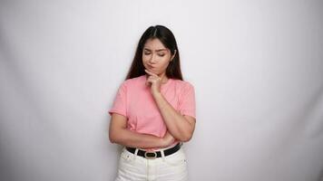 Thoughtful young woman is wearing pink shirt while looking aside in Studio with White background video