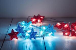 Christmas background with blue light luminous garlands and red stars on a white wooden background with copy space. photo