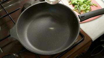 vegetable oil is poured into a preheated pan during cooking video