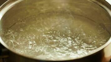 clean water boiling in stainless steel pot - slo-mo close-up video
