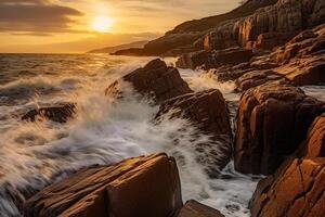 The waves are crashing over the rocks at sunset. photo