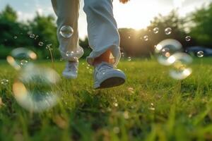 A close - up of big bubbles, blurred background of a child's legs wearing white clothes and running around on the lawn. photo