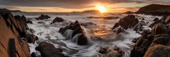 The waves are crashing over the rocks at sunset. photo