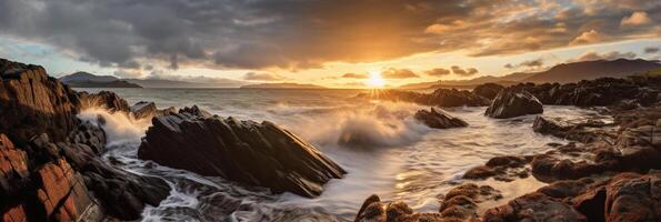 The waves are crashing over the rocks at sunset. photo