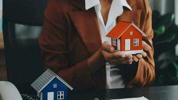 Female woman hands holding home model, small miniature white toy house. Mortgage property insurance dream moving home and real estate concept video