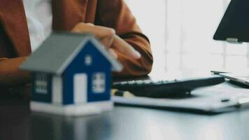 Female woman hands holding home model, small miniature white toy house. Mortgage property insurance dream moving home and real estate concept video