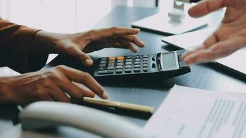 Close up Business woman using calculator and laptop for do math finance on wooden desk, tax, accounting, statistics and analytical research concept video