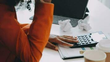 Close up Business woman using calculator and laptop for do math finance on wooden desk, tax, accounting, statistics and analytical research concept video