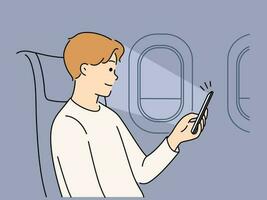 joven hombre sentar en avión utilizando Teléfono móvil artilugio. sonriente masculino vistazo teléfono inteligente en vuelo. tecnología y volador. vector ilustración.