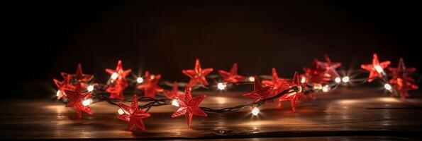 Christmas background with blue light luminous garlands and red stars on a white wooden background with copy space. photo