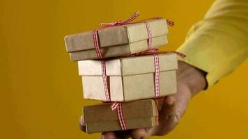 hand- houden eigengemaakt geschenk doos tegen geel achtergrond video