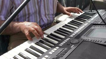 senior men hands playing grand piano at street . video