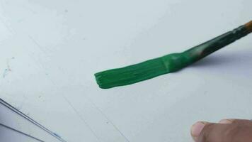 Arte cepillo con verde color en un papel video