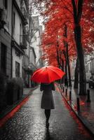 Red umbrella in hand of woman walking on a colorless street. photo