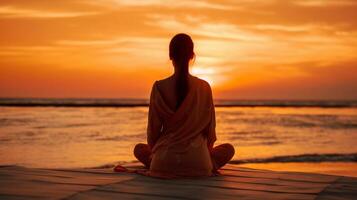 woman meditating on the beach at sunset. photo