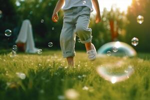 A close - up of big bubbles, blurred background of a child's legs wearing white clothes and running around on the lawn. photo